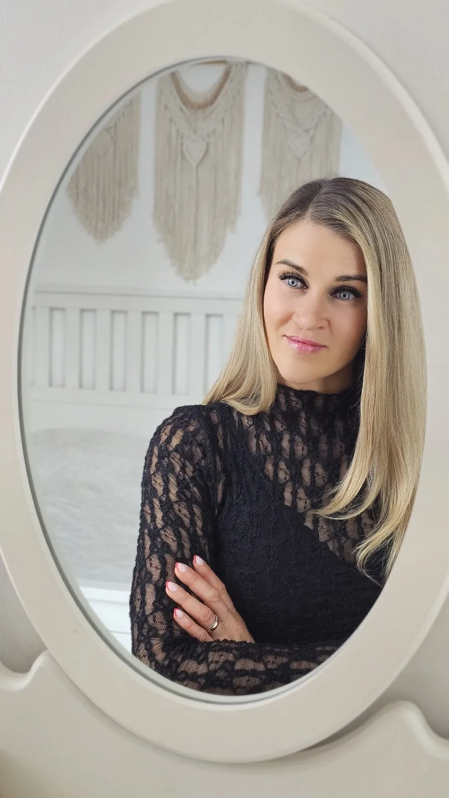 Natalie Leer in dunkler Spitze, im ovalen Spiegel gesehen