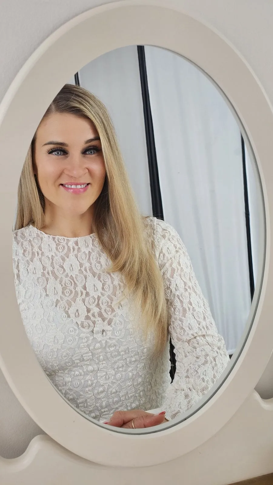 Natalie Leer in heller Spitze, im ovalen Spiegel gesehen